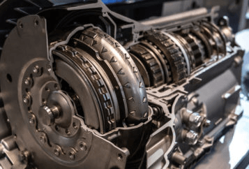 Cutia de viteze este parte a mecanismului de transmisie al unui automobil, cu rolul de a transmite puterea de la motor la roti, intr-un mod variabil, controlat, prin schimbarea rapoartelor de transmisie cu ajutorul schimbatorului de viteze. Cutia de viteze poate fi manuala sau automata, in functie de autovehiculul condus. Statistic, in Europa sunt preferate autoturismele echipate cu cutii de viteze manuale, iar in America de Nord cele echipate cu cutii de viteze automate (probabil datorita distantelor foarte mari parcurse intre doua localitati, cand lipsa pedalei de ambreiaj aduce un plus de confort conducatorului auto). Cutia de viteze are un rol deosebit de important, iar defectiunile sunt, de cele mai multe ori, cauzate de proasta intretinere sau utilizarea necorespunzatoare. Cand se schimba uleiul la cutia de viteze manuala Unii specialisti spun ca uleiul din cutia de viteze manuala poate fi lasat acolo pe toata durata de rulare a autovehiculului, asa cum a venit din fabrica, fara sa fie schimbat vreodata, intrucat temperatura de functionare normala este de 60-70 de grade, si poate ajunge la cel mult 80-90 de grade in conditii extreme de canicula, aglomeratie etc., si deoarece cutia de viteze este etansa, nu se pierde ulei, ideal este sa nu umblam acolo decat foarte rar, doar ca sa verificam nivelul. Daca este sub nivel, cauza este o pierdere la garnituri. Cand uleiul si-a schimbat proprietatile si nu mai asigura ungerea cum trebuie, cand s-a depus span, mici aschii cazute de pe pinioane, sau pilitura de fier, ele vor contamina uleiul care devine abraziv. In toate situatiile este obligatoriu sa va deplasati la un service pentru control. Dupa orice interventie in interiorul cutiei de viteze este necesara inlocuirea uleiului de transmisie. Producatorii mentioneaza durata la care se inlocuieste uleiul din cutia de viteze, pentru fiecare model in parte, in cartea masinii sau in carnetul de garantii. Iata cateva exemple, strict informative: Honda la 120.000 km sau 8 ani; BMW E39 la 35 - 40.000 km; Land Rover Sport la 48.000 km; Skoda la 90 - 100,000 km; Dacia Logan la 70 - 100.000 km. In lipsa acestor date se recomanda schimbarea lui intre 50.000 - 80.000 km, sau la 2-3 ani de functionare. Mai usor este sa identificati ce tip de ulei este potrivit pentru autovehiculul dvs., pentru ca orice distribuitor acceseaza aplicatia pe calculator si in baza codului de motor sau al codului VIN al masinii, va ofera, functie de pret, cateva marci compatibile, de calitati diferite. Deja din acest moment, producatorul uleiului este cel care specifica durata optima la care recomanda realizarea urmatorului schimb, pe care o veti nota in carnetul de intretinere al masinii. Totusi exista simptome clare care atentioneaza ca trebuie schimbat uleiul si de ele trebuie tinut cont cu prioritate, pentru ca si in acest caz preventia poate lungi durata de viata a cutiei: Pete de uleiului de transmisie sub masina. Poate fi ceva intamplator, si nu neaparat o problema la cutia de viteze, dar daca scurgerea se repeta, verificati nivelul uleiului. Se poate sa se fi pierdut din cauza unor scurgeri ascunse (de exemplu la planetare). Lipsa parțiala sau totala a uleiului din cutie poate fi mai periculoasa decat daca uleiul nu a fost schimbat la timp. Uleiul de transmisie are aspectul modificat. El este de obicei de un rosu clar, iar la atingere este vascos, gros, cu miros dulceag. Daca s-a inchis la culoare, a devenit opac si s-a subtiat, inseamna ca a suferit modificari care anunta o defectiune tehnica. Se simte un miros ca de ars dupa o functionare indelungata, din cauza frecarilor puternice ale pieselor supraincalzite din lipsa de ulei. Cand schimbati treptele de viteze se aude un zgomot anormal, metalic sau infundat, sacadat sau intens, mai puternic atunci cand maneta este in punctul mort. La schimbarea treptelor de viteze, fie cupleaza mai greu, fie maneta sare singura din viteza. Cand se schimba uleiul la cutia de viteze automata La autovehiculele cu transmisie automata situatia difera. Cutia automata functioneaza pe baza unor circuite hidraulice, utilizand un lichid similar cu cel de servo-directie. Acesta este un ulei mult mai lichid decat cel de la cutia manuala, pentru ca este solicitat la o temperatura mai mare. Constructiv, o pompa impinge uleiul cu presiune, el se incinge, asa ca de multe ori cutiile automate au nevoie de radiatoare de racire. Denumirea de cutii automate este improprie. In realitate avem transmisii automate realizate constructiv in diverse moduri: Cu cutie secventiala, in care se schimba treptele secvential. Inginerii au apelat la mecanisme complicate care sa schimbe vitezele fara ca soferul sa apese ambreiajul, dorind sa micsoreze timpul de trecere intre viteze de la o cutia manuala, asa ca in locul pedalei de ambreiaj s-a montat un actuator hidraulic, electric sau mecanic, care, cu ajutorul unei furci, ridica si coboara ambreiajul, exact ca atunci cand ar fi actionat de o pedala. Schimbarea treptelor se face electronic, instantaneu. Cu dublu ambreiaj, alcatuita din doua cutii de viteze manuale montate in paralel. In aceeasi carcasa avem doua cutii de viteze, fiecare avand ambreiajul ei: prima actioneaza treptele impare, iar a doua pe cele pare. Marele avantaj al acestei configuratii este ca permite preselectia treptelor de viteze, facand schimbarea lor extrem de rapid, fara sa intrerupa fluxul de putere si fara ca soferul sa simta ca s-a schimbat viteza, totul comandat de un calculator. Cu cutie automata CVT (Continuous Variable Transmission), fara roti dintate, ci pe baza unei curele si patru conuri, la care iar principiul de functionare se aseamana cu lantul de bicicleta, dar in loc de pinioane avem un con, iar in loc de placi alt con. Transmisia automata CVT are un ambreiaj principal, diferit constructiv de unul obisnuit, si unul secundar, ce permite realizarea unui numar infinit de rapoarte, intre o valoare minima si una maxima a raportului de transmitere. Cu hidrotransformator (convertizor de cuplu), este cutia de viteze automata clasica, denumita si hidramata, de la cutiile de viteze automate produse de General Motors sub numele de Hydra-Matic. Si la aceste modele treptele se schimba electronic, fara interventia celui de la volan. Simptomele lipsei de ulei la cutia de viteze automata sunt sesizate automat. Conducatorului auto i se semnaleaza reducerea calitatii uleiului. Atunci cand apar simptome precum: Uleiul nu mai este de calitate, sau Este lipsa de ulei in cutia de viteze, este imperios necesar sa va prezentati de urganta la Service, pentru ca piesele din ea se vor deteriora curand. Conducerea in continuare a masinii cu simptomele de defectiune la cutia de viteze, poate duce la probleme serioase, care nu pot fi rezolvate usor. In cazul in care exista astfel de avertizari, este obligatoriu sa faceti schimbul de ulei, pentru ca lipsa acestuia sa nu afecteze functionarea cutiei de viteze. Revizia periodica a transmisiilor automate Un factor important in intretinerea cutiei automate este efectuarea reviziei la intervalul de timp specificat de producatorul automobilului in manualul de intretinere al fiecarui autovehicul. Intretinerea cutiilor hidramate presupune schimbarea consumabilelor si revizia acestora la un service autorizat pentru cutii automate. Majoritatea cutiilor automate moderne vin echipate cu un filtru de ulei, la fel ca un motor. Acesta este de cele mai multe ori o sita, care trebuie schimbata sau curatata din cand in cand, fiind metalica, dar sunt si altele mai noi care au filtre aproape identice cu cele de la motor si care trebuiesc inlocuite la fiecare schimb de ulei. Autovehiculele de performanta echipate cu transmisii hidraulice care functioneaza la turatii mari au filtre de unica folosinta, care se inlocuiesc pe sub masina, desfacand partea inferioara a cutiei (baia de ulei), apoi se schimba filtrul si garniturile si abia apoi se introduce ulei nou. Schimbarea uleiului de transmisie la cutiile automate se recomanda a se face la fiecare a treia schimbare a uleiului din motor sau la un maxim de km, diferit pentru fiecare tip de ulei. Uleiurile de transmisie nu sunt toate la fel si, foarte important, nu sunt interschimbabile unul cu altul. Fiecare transmisie are nevoie de un anumit tip de ulei de transmisie pentru functionarea optima. Utilizarea unui alt tip de ulei poate provoca defectiuni sau poate anula garantia. Daca nu este specificat in manualul de utilizare al masinii tipul de ulei, puteți apela la un selector online de uleiuri sau la un specialist, pe baza codului de motor, sau a codului VIN al masinii. Iata si aici cateva exemple, strict informative: Honda la 120.000 km sau la 8 ani; Audi la 120.000 km; Peugeot la 120.000 km; Hyundai la 120.000 km si Ford tot la 120,000 km. In concluzie, utilizarea uleiului de transmisie corect creste durata de viata a transmisiei, mecanice sau automate, reduce uzura si prelungeste durata de functionare a cutiei de viteze.